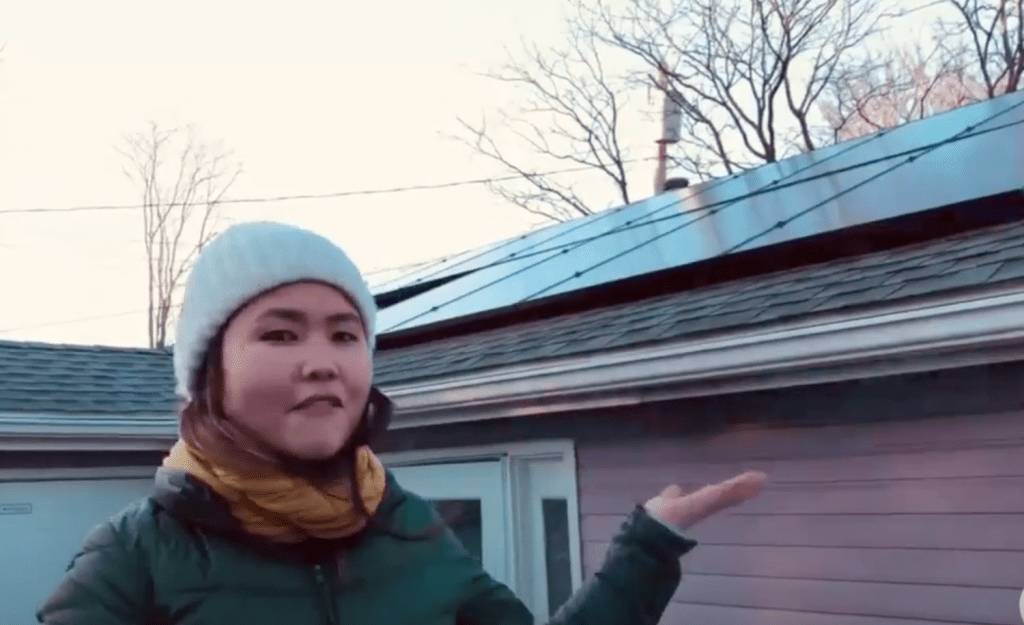 woman displaying her rooftop solar panels